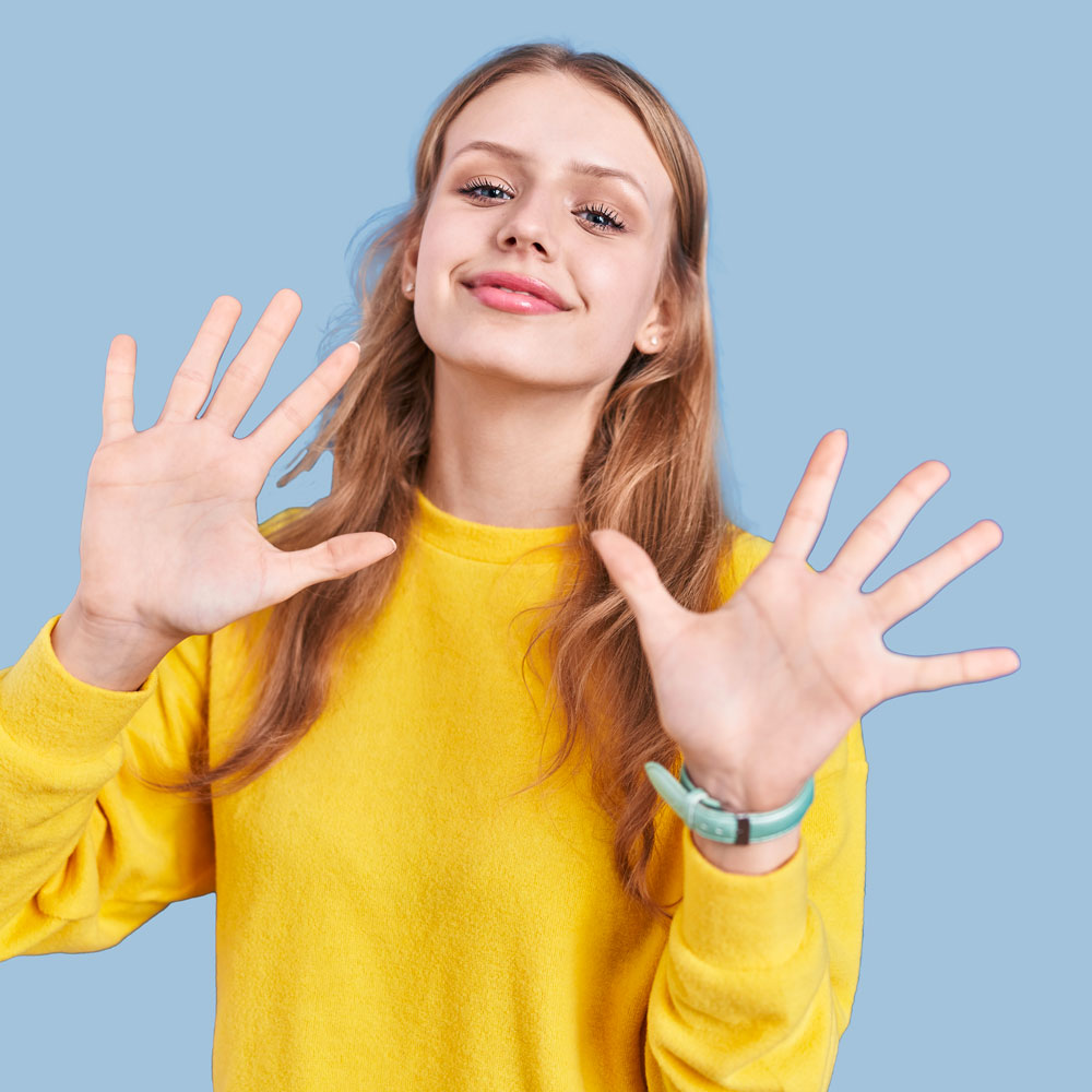 ragazza vestita di giallo mostra i 10 benefici laminazione ciglia